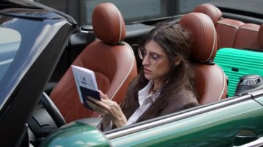 Arabasında oturan bir kadın seyahat belgelerini kontrol ediyor. Sürücü, elinde pasaport ve biletlerle yolculuğa hazır. 4K