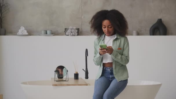 Černá Žena Píše Smsky Svém Smartphonu Jak Sedí Koupelně Millennial — Stock video