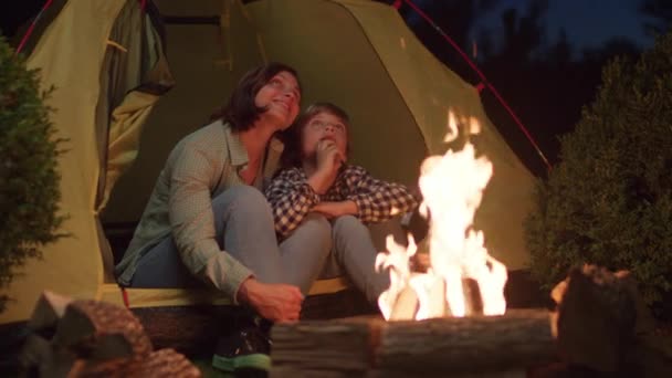 妈妈和儿子坐在火边的帐篷里 一家人一起享受着露营的夜晚 一起仰望夜空 — 图库视频影像