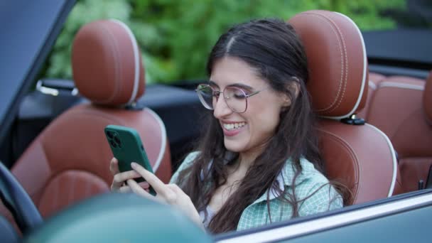 年轻的成年女子在车里浏览智能手机 女司机用手机 — 图库视频影像