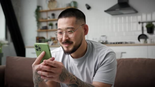 男子在相机前显示智能手机绿色屏幕 微笑的亚洲男人拿着彩色的关键屏幕在镜头前 — 图库视频影像