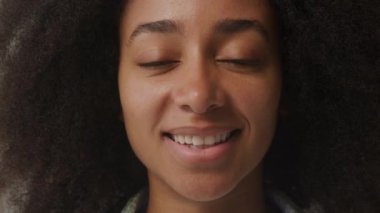 Afro-Amerikan Kadın Portresi. Afro-Amerikalı kadın kameraya bakıp gülümsüyor. Ağır çekim. 4K