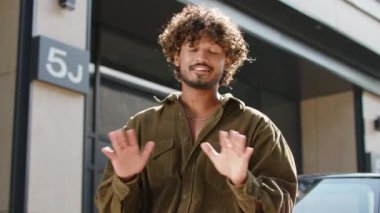 Dışarıda kamerada konuşan 20 'li yaşlarda bir adam. Gülümseyen olumlu erkek kameraya bakıyor. 4K