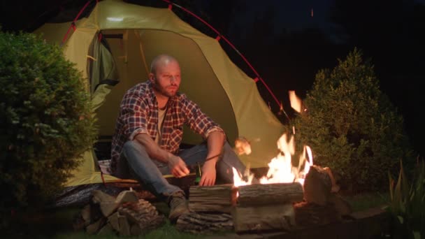 30S Man Grillen Worstjes Boven Kampvuur Drinken Bier Zittend Tent — Stockvideo