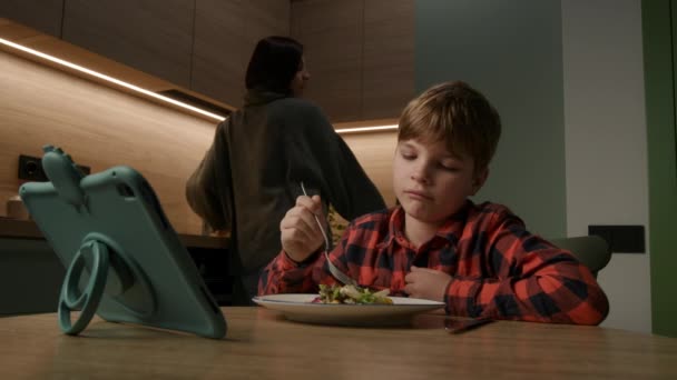 子供はタブレットコンピュータを見ながら食事をする 母は介入し 健康的な習慣を促進する 育児とライフスタイルのコンテンツ — ストック動画