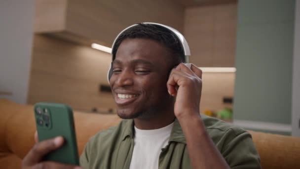 Hombre Afroamericano Serenata Con Alegría Usando Auriculares Sosteniendo Teléfono Celular — Vídeos de Stock