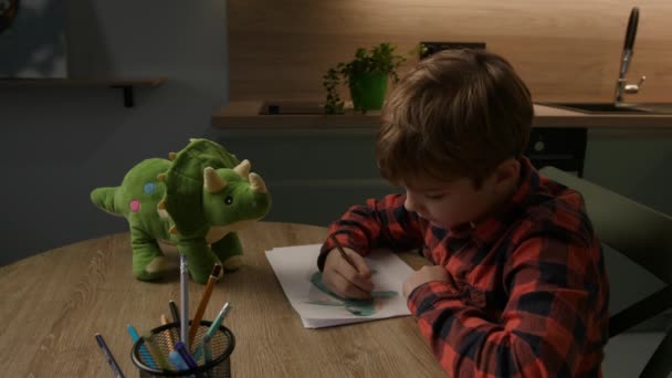 Menino Anos Alegremente Desenha Seu Brinquedo Dinossauro Favorito Com Traços — Vídeo de Stock