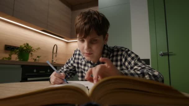 12歳の少年は教科書に集中し 自宅で宿題を書いている アクションのアカデミックな献身 — ストック動画