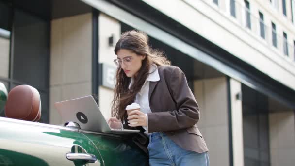 Empowered Focused Female Entrepreneur Stands Outdoors Typing Her Laptop Sipping — Stock Video