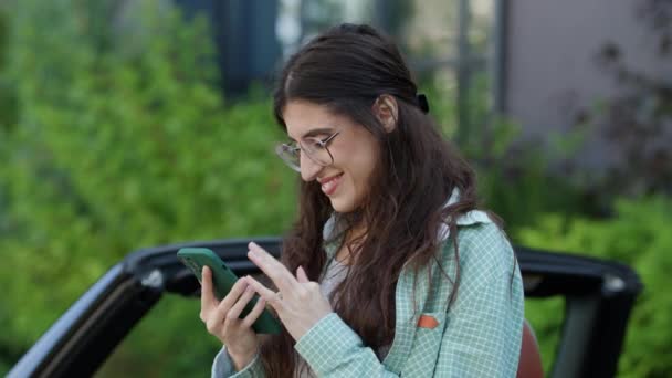 携帯電話を使用して カメラで緑色の画面を表示する女性 カメラでクロマキーを握っている眼鏡の女性 4Kについて — ストック動画