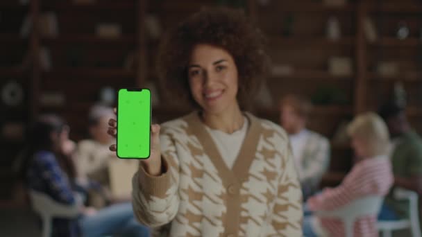 Uma Mulher Radiante Com Cabelo Encaracolado Mostra Alegremente Smartphone Com — Vídeo de Stock