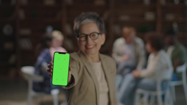 Seorang Terapis Tersenyum Memegang Smartphone Dengan Layar Hijau Depan Kelompok — Stok Video