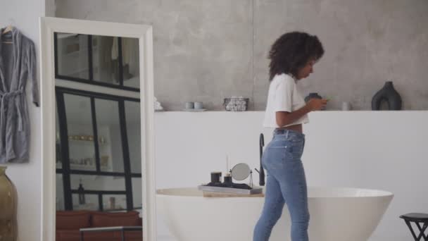 Młoda Kobieta Skupiona Sms Owaniu Przez Telefon Stojąca Stylowej Łazience — Wideo stockowe