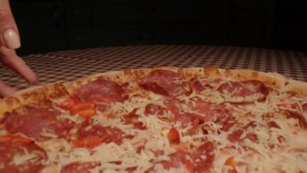 チーズペッパーニピザからスライスを取る手をキャプチャするクローズアップドーリーショット — ストック動画
