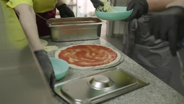 Руки Перчатках Щедро Добавляют Сыр Томатный Соус Тесто Пиццы — стоковое видео