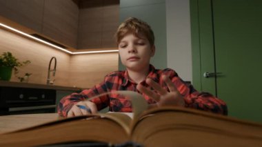 Çocuk ödevine odaklanmış, özen ve konsantrasyon gösteriyormuş. Eğitim, öğrenim ve aile temalı projeler için ideal.