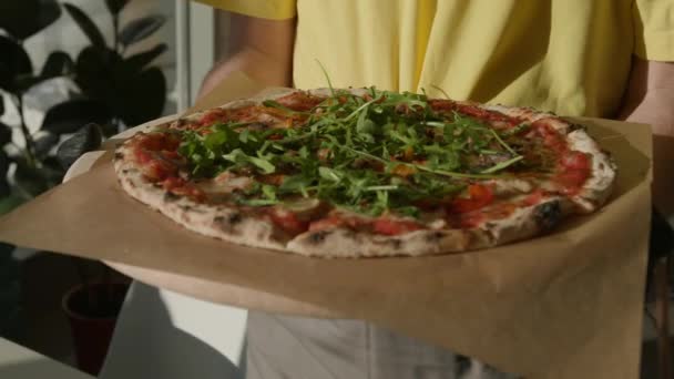 Persoon Geel Shirt Met Een Pizza Bedekt Met Arugula — Stockvideo