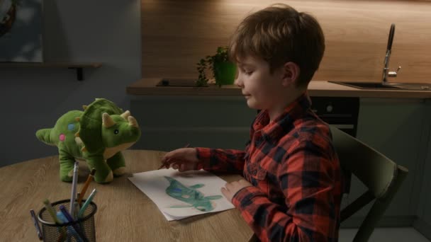 8岁的男孩以五彩斑斓的笔触 欢快地画着他心爱的恐龙玩具 表现出他的创造力和天真 完美的家庭 教育和艺术主题 — 图库视频影像