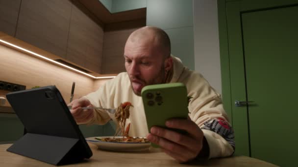 男人吃意大利面 忙着用技术设备 — 图库视频影像