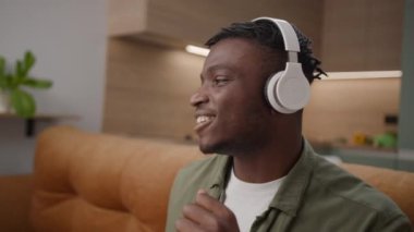 Kulaklıklı mutlu adam telefon tutuyor.