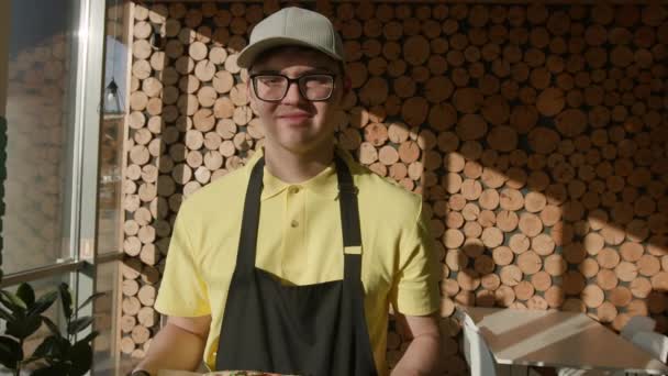 Omhelzende Inclusiviteit Een Cafémedewerker Met Neurodiversiteit Die Pizza Vasthoudt Die — Stockvideo