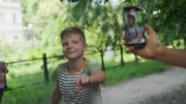 Neşeli bir anı yakalayan bir anne, çocuğunun cep telefonuyla dans edişini kaydediyor ve çocukların online yaşamlarını paylaşma eğilimini gösteriyor.