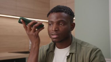Siyah adam cep telefonuyla sesli mesaj kaydediyor. 30 'lu yaşlardaki bir adam evde telefonla konuşuyor. 4K