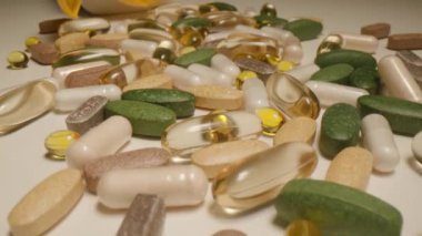 Masaya saçılmış hapları, ilaçları ve ilaçları yakalayan bir oyuncak bebek resmi. Sağlık ve tedavi gereksinimlerini temsil eden çeşitli ilaçların ayrıntılı bir görünümü