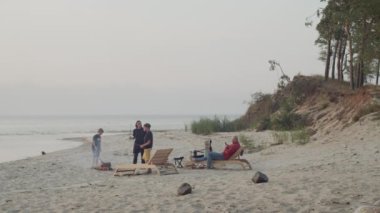Anne, baba ve iki oğlu da dahil olmak üzere dört kişilik bir aile, vahşi bir plajda bir yaz gecesinin keyfini çıkarıyor. Deniz kıyısında yürek ısıtan bir bağ ve rahatlama anı.