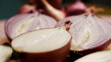 Tahta kesme tahtasına yerleştirilmiş kırmızı, sarı ve beyaz soğanlar da dahil olmak üzere çeşitli soğan parçalarının yakın çekim görüntüleri. Mutfak, yemek ve sağlıklı besinler için mükemmel.