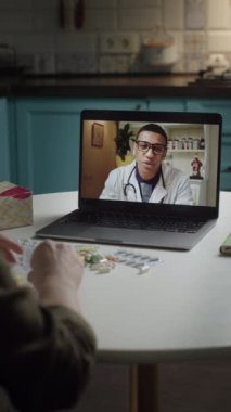 Bir hasta, tıbbi test sonuçlarını incelerken evinden bir çevrimiçi doktora danışmanlık yapar. Teletıp, dijital sağlık hizmetleri, uzaktan teşhis ve sanal tıbbi konsültasyonlar için ideal