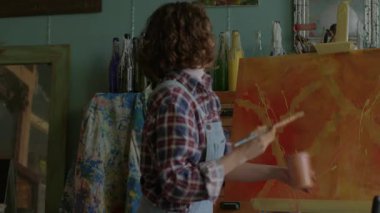 Easel 'da Resim Yapan Kadın. Tuvale resim çizen konsantre sanatçı. 4K