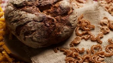 Tahta bir masanın üzerine düzgün yerleştirilmiş kepekli ekmeğin yakın plan görüntüsü. Sağlıklı yeme, pişirme, beslenme ve sağlıklı yaşam tarzlarıyla ilgili konular için mükemmel.