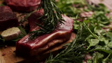 Biberiye dalının çiğ bifteğe zeytinyağı sürerken yakın plan bir fotoğrafı. Aşçılık, aşçılık ve gurme yemek temaları için mükemmel.