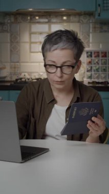 Olgun bir kadın elinde ABD pasaportu tutarken online form dolduruyor. Seyahat temaları, vize başvurusu, çevrimiçi belgeler, göç ve dijital evraklar için ideal