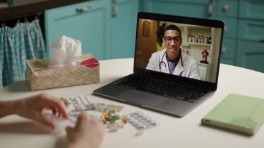 Bir hasta, tıbbi test sonuçlarını incelerken evinden bir çevrimiçi doktora danışmanlık yapar. Teletıp, dijital sağlık hizmetleri, uzaktan teşhis ve sanal tıbbi konsültasyonlar için ideal