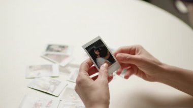 Olgun ellerin nazikçe anlık fotoğrafları tutması, geçmiş anıları yad etmesi. Nostaljik ve duygusal sahne. Hafıza, nostalji ve sevgi dolu deneyimler için mükemmel..
