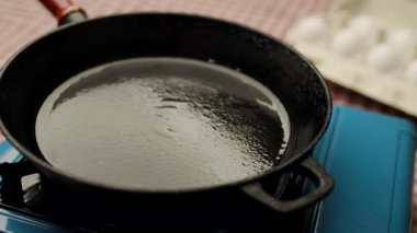 Çiğ yumurtanın çatırdadığı ve sıcak bir tavanın üzerine düştüğü yakın plan bir çekim, temas üzerine cızırtı. Yemek pişirmek, kahvaltı hazırlamak ve yemek hazırlamak için mükemmel..
