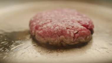 Sulu sığır pirzolası tavada kızartılıyor, lezzetli bir ev yapımı burger için mükemmel pişerken yağla cızırdıyor. Yemek, yemek ve tarif içeriği için mükemmel..