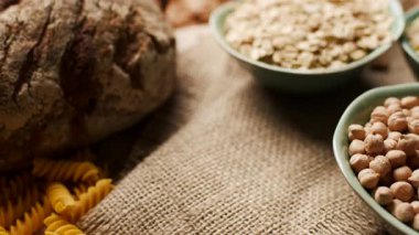 Bir el, bir kase dolusu pirinci ve diğer karbonhidratlı gıdaları masaya yerleştirirken. Beslenme, sağlıklı beslenme ve yemek hazırlama konuları için mükemmel.