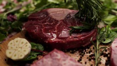 Biberiye dalının çiğ Osso Buco bifteğine zeytin yağı sürerken yakın plan bir fotoğrafı. Aşçılık, aşçılık ve gurme yemek temaları için mükemmel.