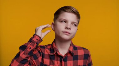 Genç bir çocuk, eli yüzüne yakın bir şekilde 