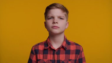 Genç bir çocuk iki eliyle kulaklarını kapatıyor, 