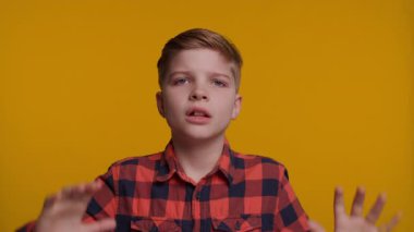 Genç bir çocuk elleriyle kulaklarını kapatırken 