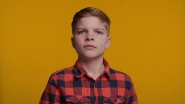 Genç bir çocuk avuç içi kameraya dönük bir şekilde elini kaldırır ve 