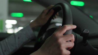 Bir kadının direksiyona sıkıca tutunduğu yakın plan bir fotoğraf, araba kullanırken odaklanma ve kontrol anı yakalıyor..