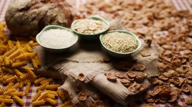 Bir el karbonhidrat zengini yiyeceklerle dolu bir kaseyi masaya yerleştirirken çekilmiş yakın plan bir fotoğraf. Beslenme, sağlıklı yemek ve yemek hazırlama kavramları için idealdir.