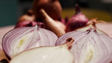 Tahta kesme tahtasına yerleştirilmiş kırmızı, sarı ve beyaz soğanlar da dahil olmak üzere çeşitli soğan parçalarının yakın çekim görüntüleri. Mutfak, yemek ve sağlıklı besinler için mükemmel.