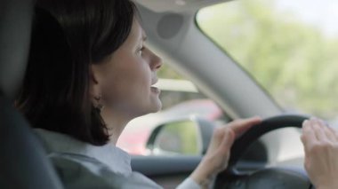 Bir kadın şarkı söyleyerek ve dans ederek araba sürerken eğlenirken kaygısız neşesini ve enerjisini ifade eder..