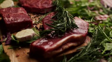 Köy ahşap bir masada sergilenen T-bone ve Osso Buco kesikleri de dahil olmak üzere farklı türde çiğ biftek. Aşçılık, yemek pişirme ya da kasaplık için mükemmel.